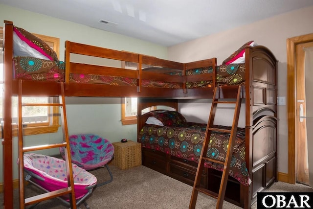 carpeted bedroom featuring visible vents