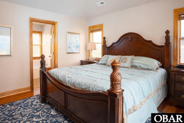 bedroom featuring visible vents, baseboards, and wood finished floors