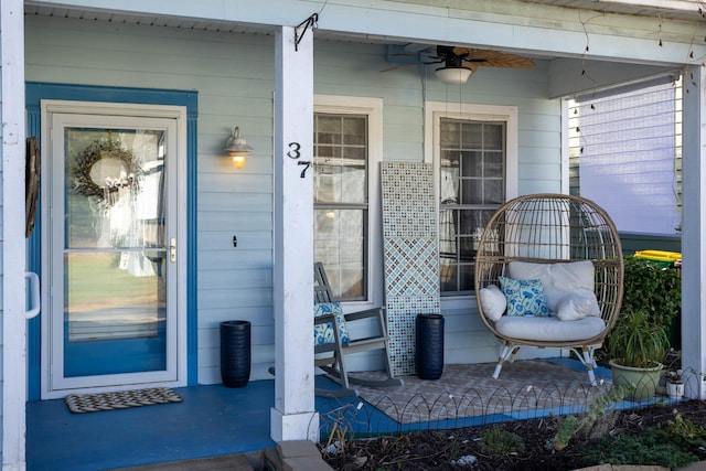 view of exterior entry with a porch and a ceiling fan