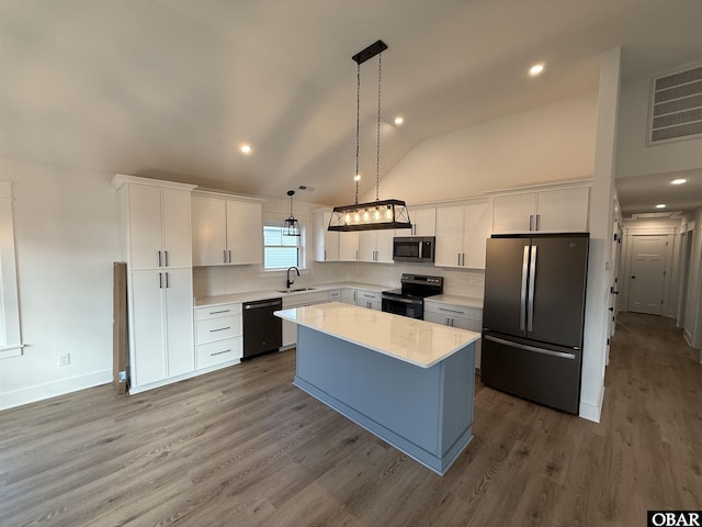 615 W Aycock St Unit 5-7, Kill Devil Hills, NC 27948 - kitchen featuring stainless steel appliances, white cabinets, light countertops, a center island, and decorative backsplash