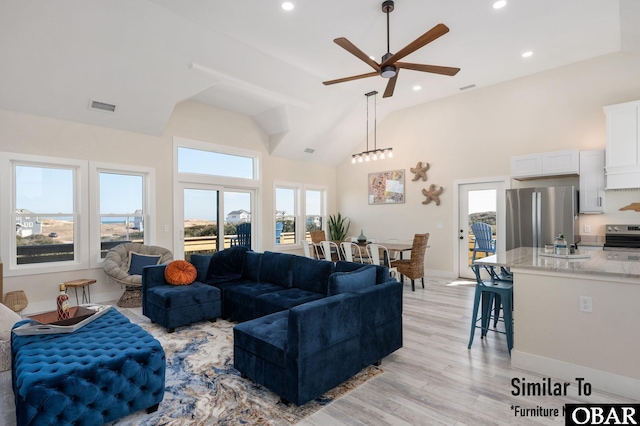 living area with high vaulted ceiling, light wood-style flooring, visible vents, and recessed lighting