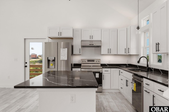 2002 Sandpiper Rd Lot 12, Corolla, NC 27927 - kitchen featuring stainless steel appliances, under cabinet range hood, light wood-style floors, a center island, and vaulted ceiling