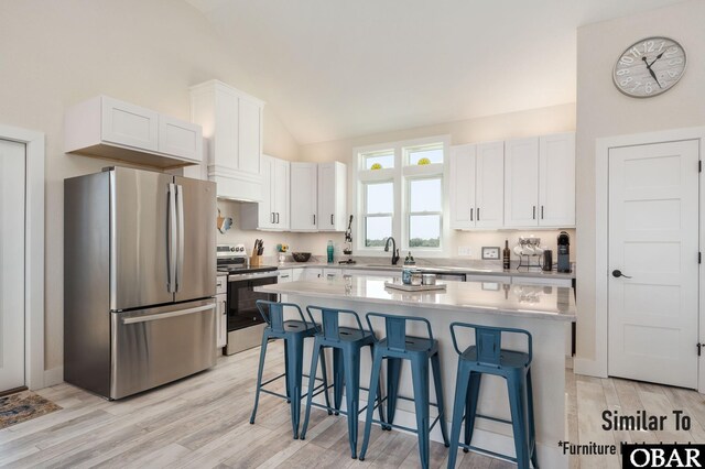 kitchen with white cabinets, stainless steel appliances, and a kitchen breakfast bar