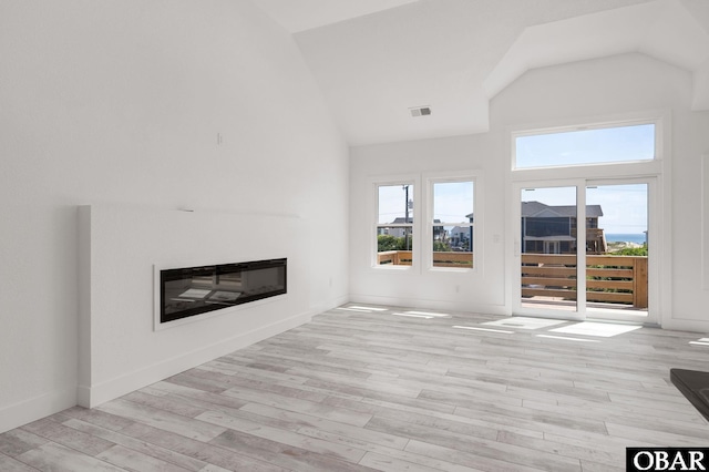 2002 Sandpiper Rd Lot 12, Corolla, NC 27927 - unfurnished living room with a glass covered fireplace, light wood-style flooring, and high vaulted ceiling