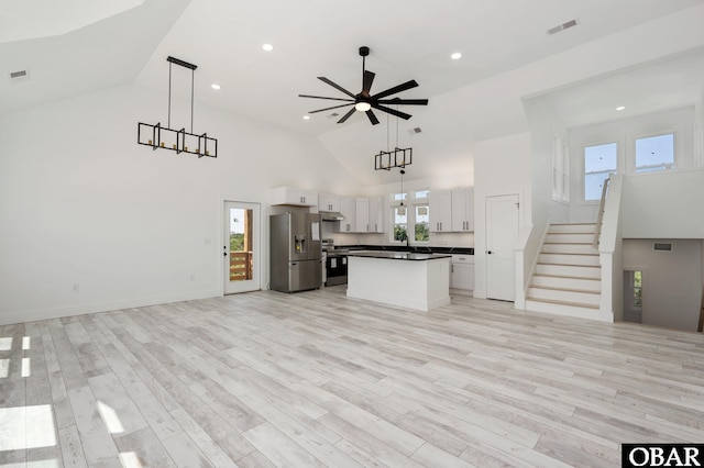 2002 Sandpiper Rd Lot 12, Corolla, NC 27927 - kitchen featuring high vaulted ceiling, stainless steel appliances, open floor plan, dark countertops, and white cabinets