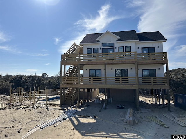 view of front of home featuring stairs, roof with shingles, and board and batten siding