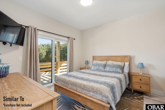 bedroom featuring access to exterior, baseboards, and wood finished floors