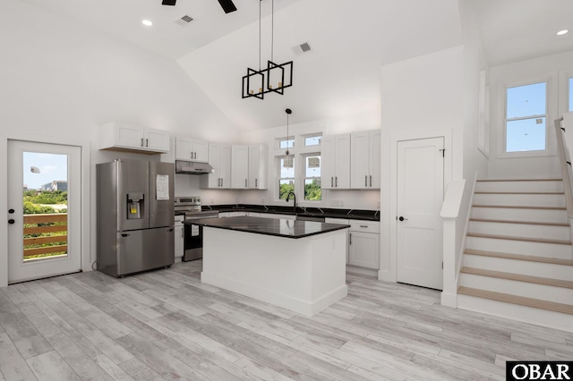 2002 Sandpiper Rd Lot 12, Corolla, NC 27927 - kitchen featuring appliances with stainless steel finishes, under cabinet range hood, high vaulted ceiling, white cabinets, and dark countertops