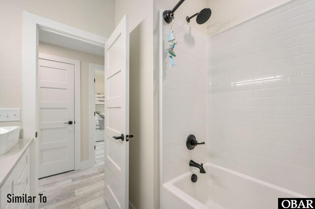 bathroom with shower / washtub combination, wood finished floors, and vanity