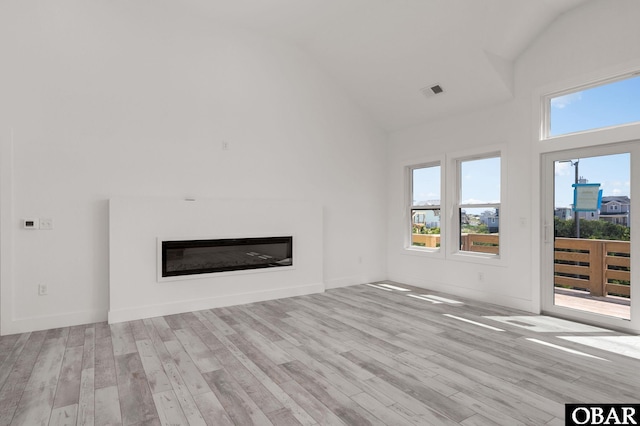 2002 Sandpiper Rd Lot 12, Corolla, NC 27927 - unfurnished living room with high vaulted ceiling, a glass covered fireplace, and wood finished floors