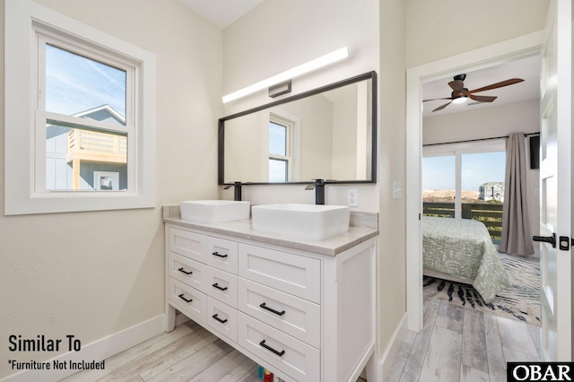 full bath featuring connected bathroom, a sink, and wood finished floors