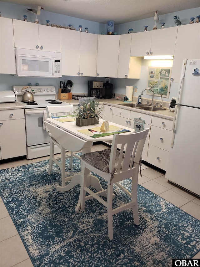 kitchen featuring a sink, light countertops, white appliances, and white cabinetry