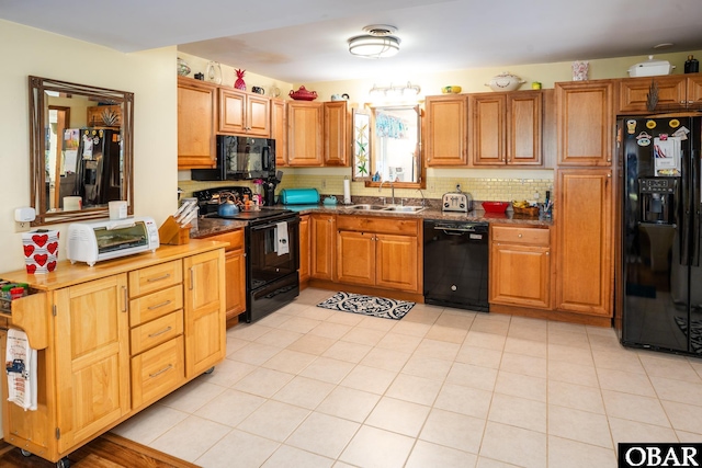 kitchen with a sink, brown cabinetry, decorative backsplash, a toaster, and black appliances