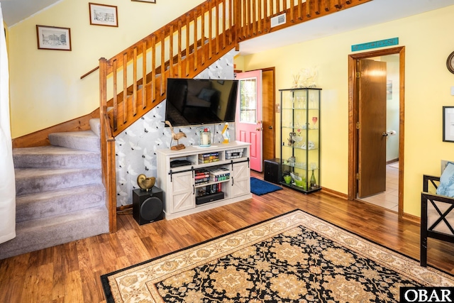 living area featuring visible vents, baseboards, stairs, and wood finished floors