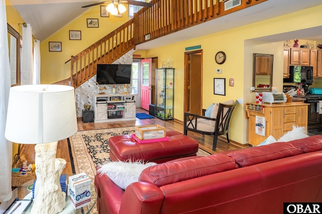 living area with stairs, ceiling fan, visible vents, and wood finished floors
