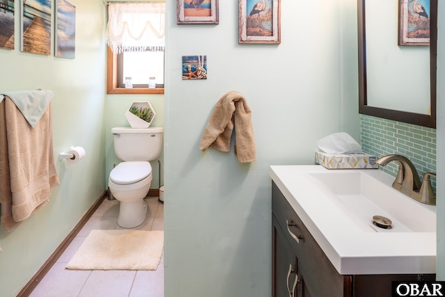 bathroom featuring vanity, toilet, tile patterned floors, baseboards, and tasteful backsplash