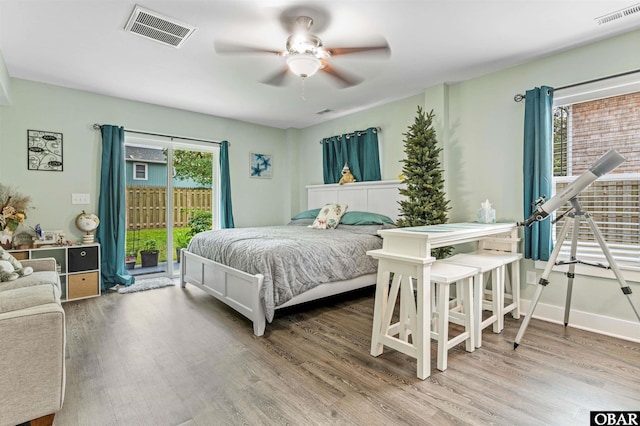 bedroom with baseboards, access to outside, visible vents, and wood finished floors