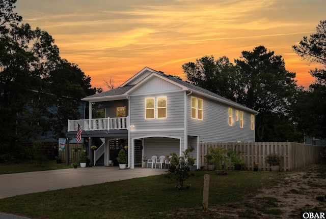 view of front of home featuring covered porch, fence, driveway, stairway, and a carport