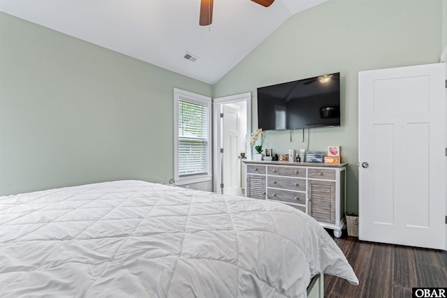 bedroom featuring dark wood-type flooring, lofted ceiling, visible vents, and a ceiling fan