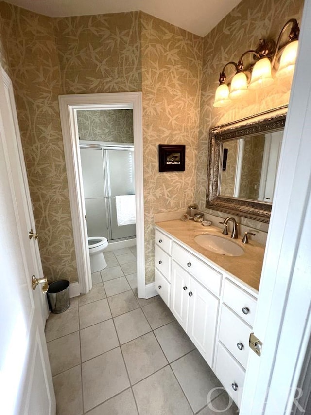 full bathroom featuring a shower stall, vanity, tile patterned flooring, baseboards, and wallpapered walls