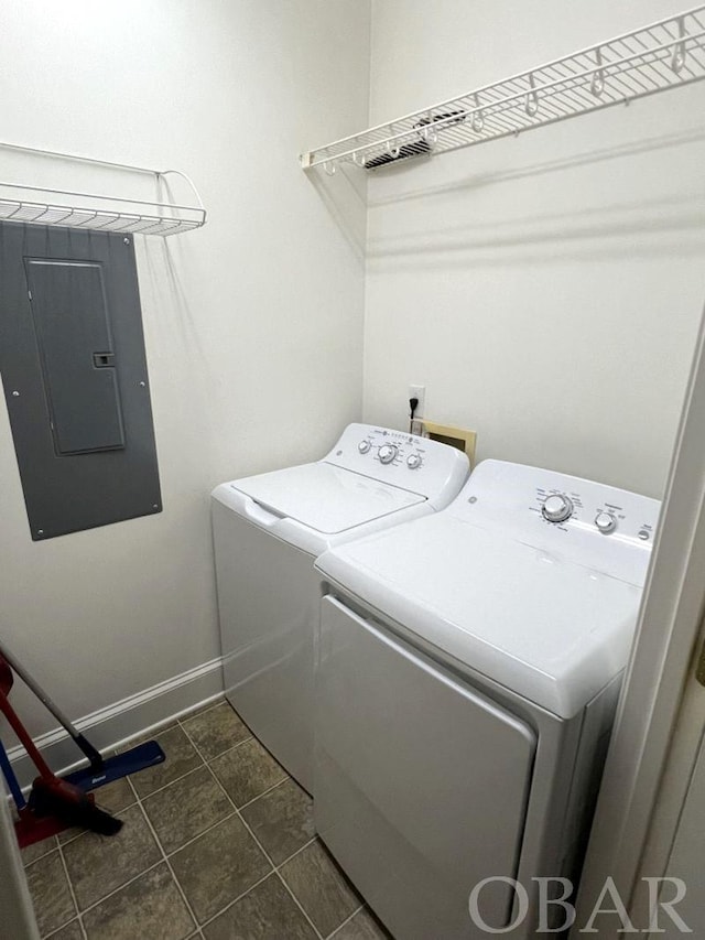 washroom with laundry area, electric panel, baseboards, independent washer and dryer, and dark tile patterned floors