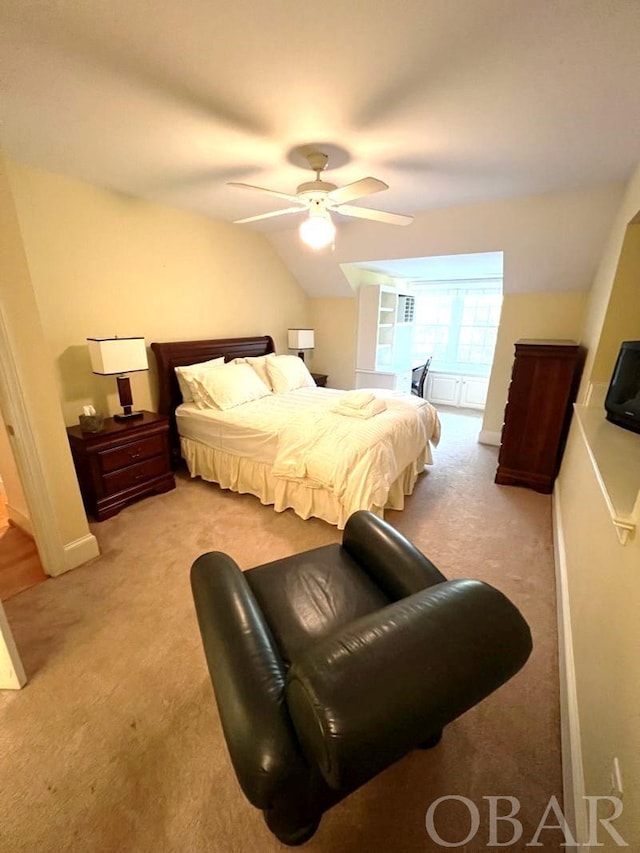 bedroom with light carpet, vaulted ceiling, a ceiling fan, and baseboards