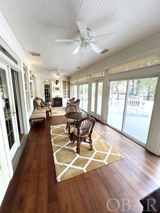 sunroom / solarium featuring a wealth of natural light, french doors, visible vents, and ceiling fan