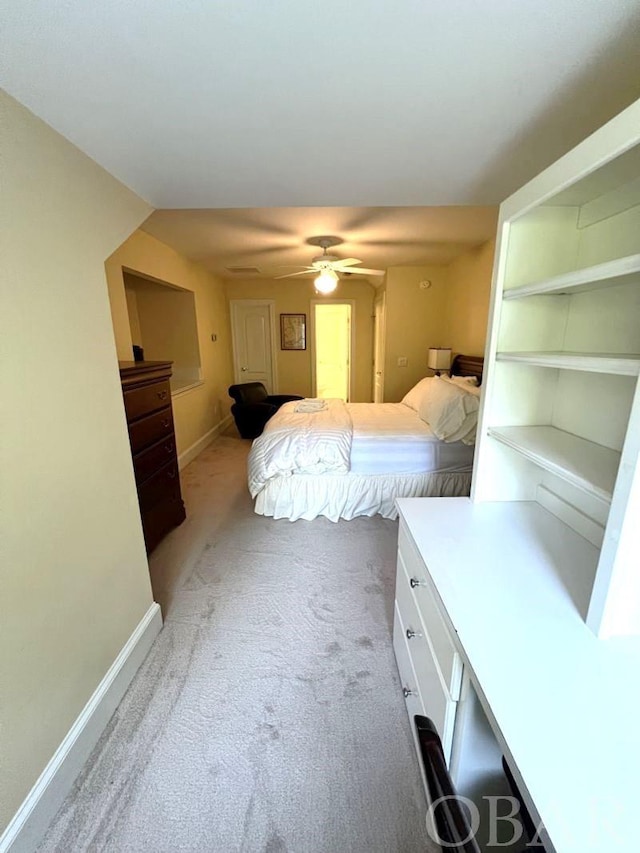 bedroom with light carpet, ceiling fan, and baseboards