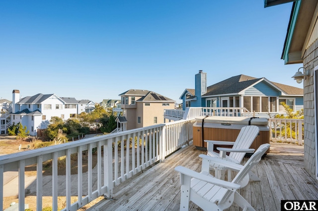 wooden deck featuring a residential view and a hot tub