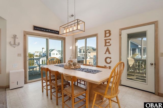 dining area featuring light floors, high vaulted ceiling, and visible vents