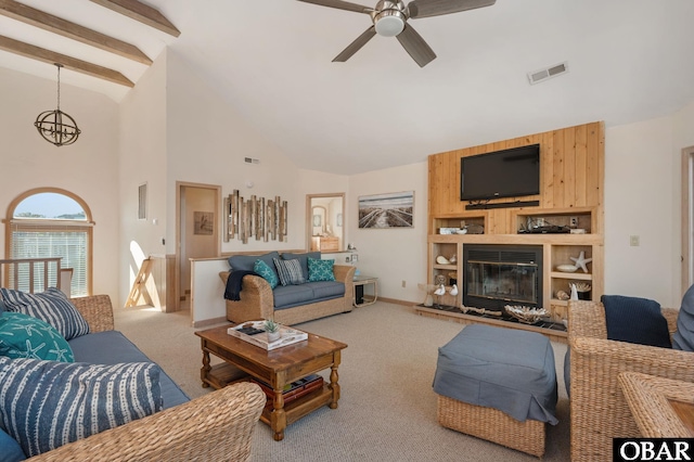 living area with light carpet, visible vents, a glass covered fireplace, and beam ceiling