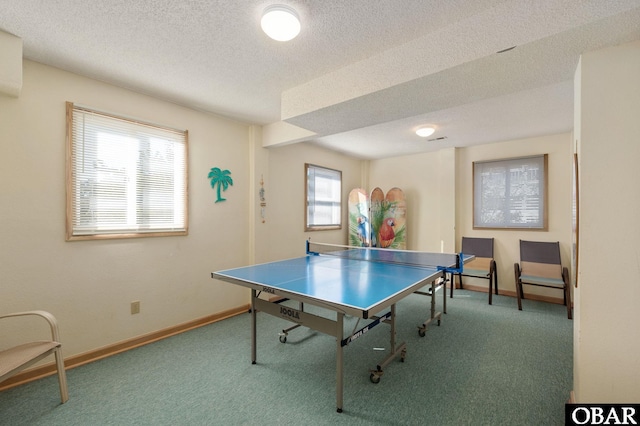 rec room featuring carpet floors, baseboards, and a textured ceiling