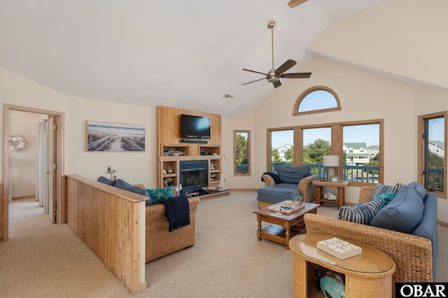 living area featuring light carpet, a large fireplace, visible vents, a ceiling fan, and high vaulted ceiling