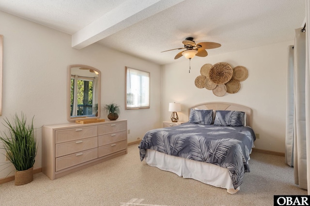 bedroom featuring a textured ceiling, ceiling fan, light carpet, baseboards, and beam ceiling