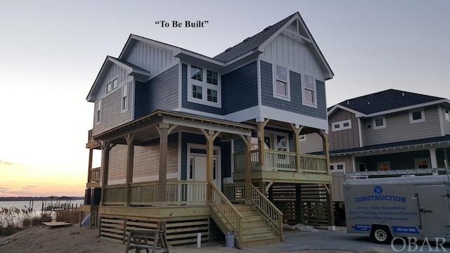 view of front of house featuring covered porch, stairway, and board and batten siding