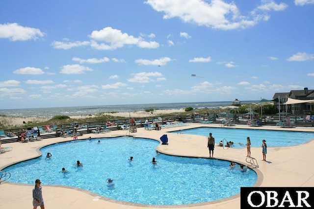 pool featuring a water view and a patio area