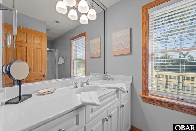 bathroom with visible vents, a stall shower, vanity, and a wealth of natural light