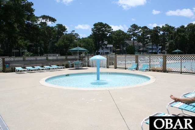 community pool with fence and a patio