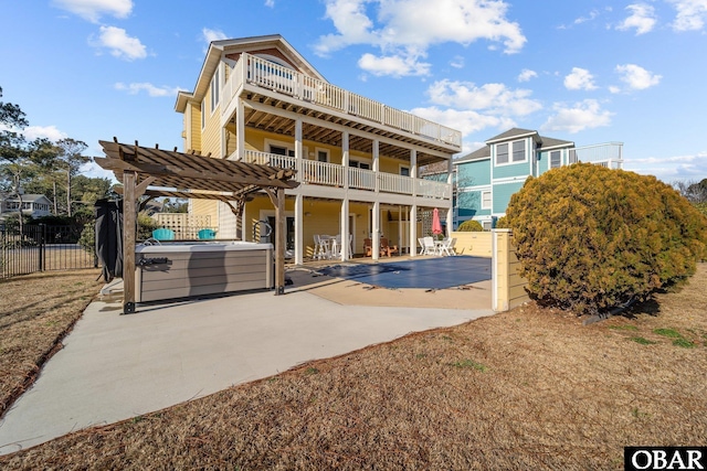 back of house with a patio, a hot tub, fence, a balcony, and a pergola