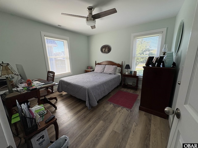 bedroom with visible vents, wood finished floors, and a ceiling fan