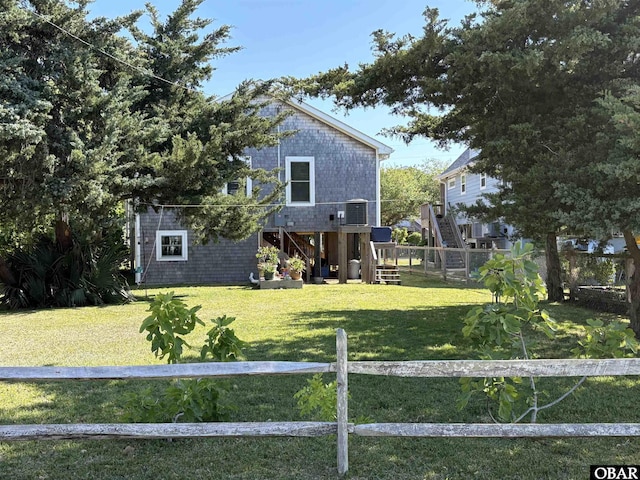 exterior space featuring a fenced backyard, a front lawn, and stairs