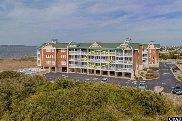 view of building exterior featuring a water view and uncovered parking