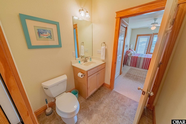 half bathroom featuring toilet, vanity, and baseboards