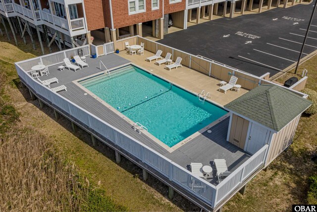 community pool with a patio area and fence