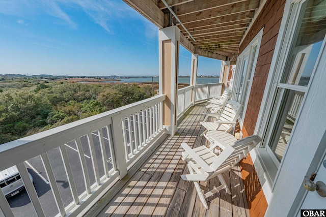 balcony featuring a water view and a sunroom