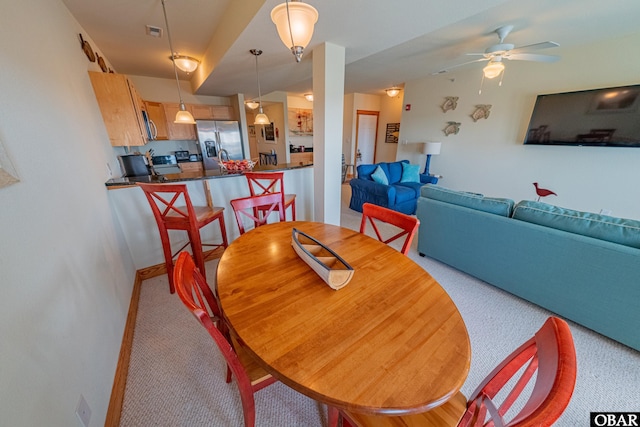 dining room featuring light carpet, visible vents, and a ceiling fan