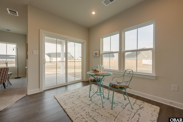 living area featuring baseboards, visible vents, and dark wood-type flooring