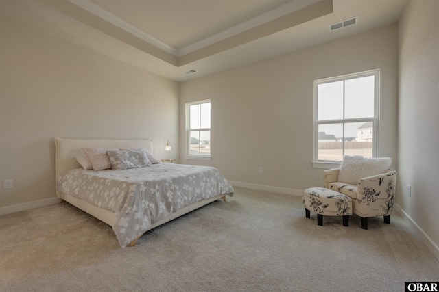 carpeted bedroom featuring a raised ceiling, visible vents, and baseboards