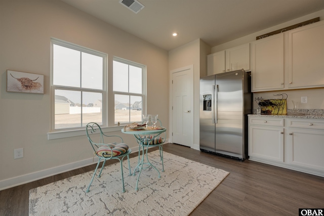 kitchen featuring baseboards, dark wood-style flooring, visible vents, and stainless steel fridge with ice dispenser