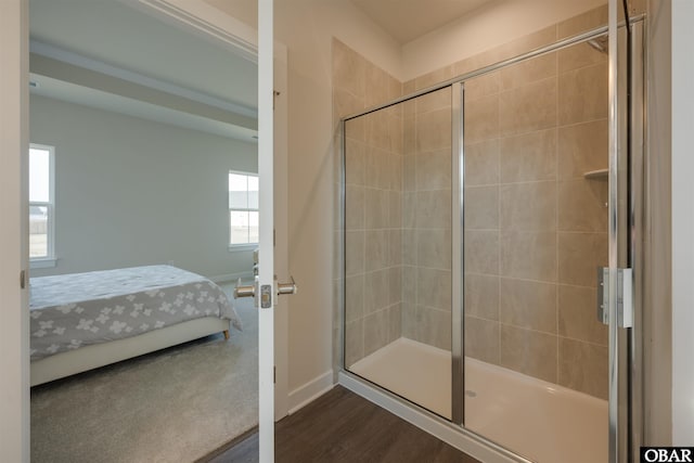 bathroom featuring ensuite bathroom, a stall shower, wood finished floors, and baseboards